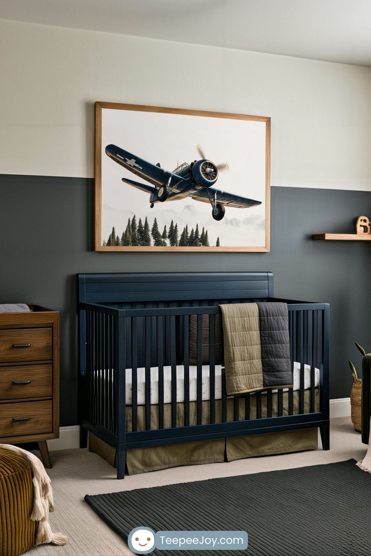 Modern nursery in deep green and earthy tones, featuring a navy crib, wood accents, and a cozy olive armchair with a tan pillow. Above the crib hangs a framed painting of a vintage navy warplane flying low over a forest, adding a bold, adventurous touch to the serene space.