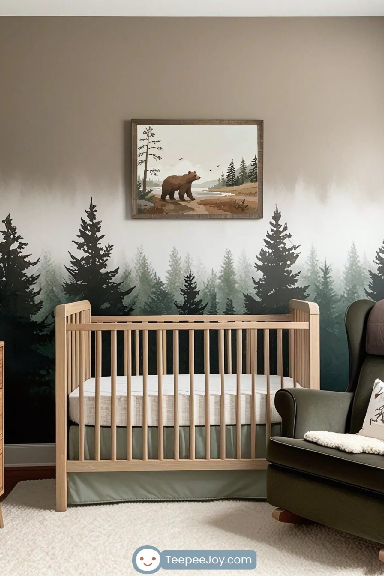 Nature-inspired nursery with a wooden crib against a mural wall featuring a misty evergreen forest. Above the crib, a framed artwork of a brown bear standing near a river in a woodland setting adds to the wilderness theme. A dark green armchair with a cozy pillow and blanket sits nearby, completing the rustic, outdoorsy aesthetic.
